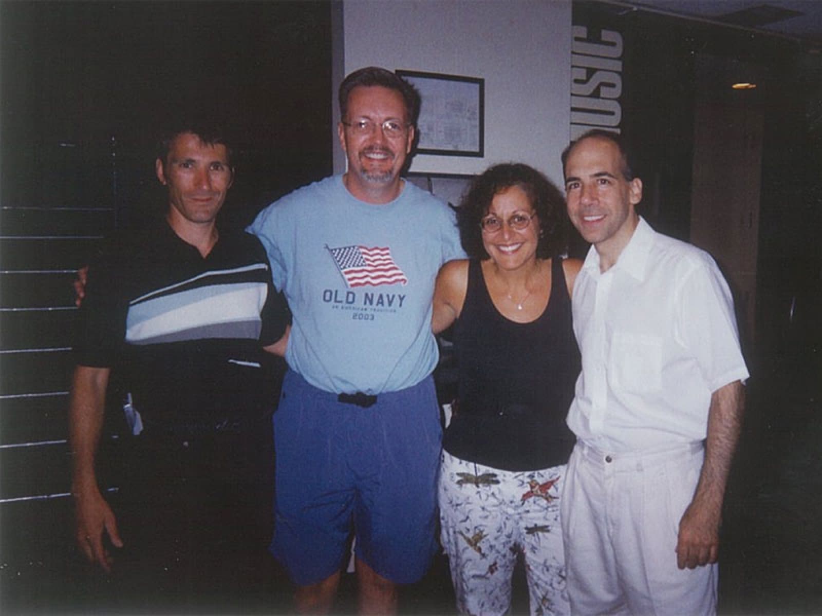 Chaz Esposito with three backstage visitors in a music hall corridor