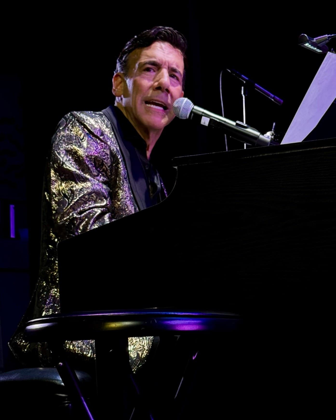 Chaz Esposito singing at the piano during a live performance