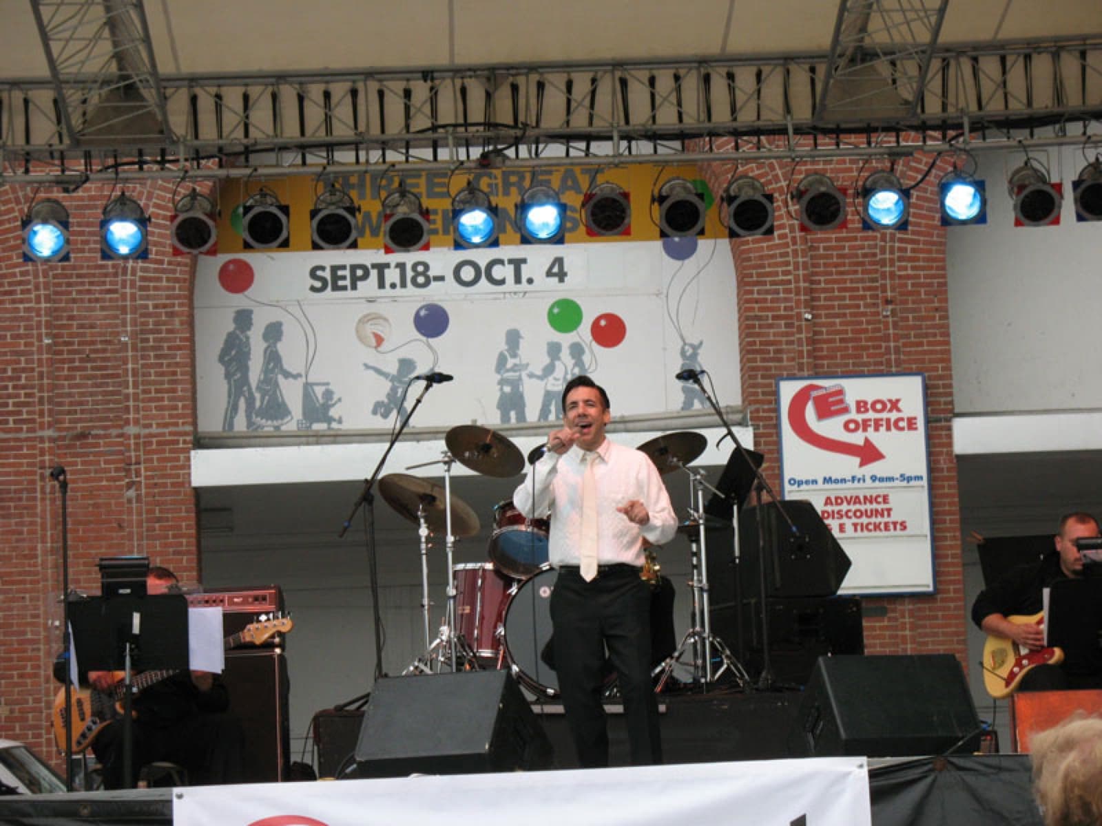 Chaz Esposito singing on a fair main stage with the band behind him